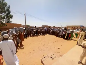 تلاميذ مصطفون في فناء المدرسة يرفعون حقائبهم الجديدة فوق رؤوسهم
